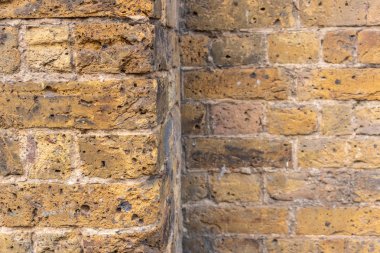 Sarı, kırmızı, turuncu ve gri renklerde tuğla duvar.