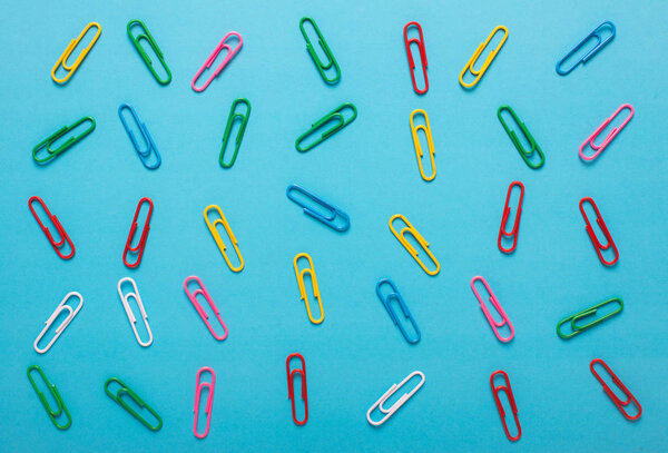 Colorful collection of paper Clips in Grouping on blue background.