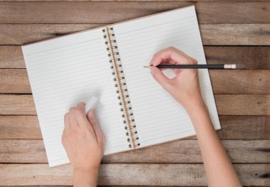 antika arka plan üzerinde üst görünümü ile kopya alanı, kitap yazma kalem ve kauçuk eraser tutan eller kadın