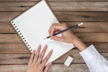 antika arka plan üzerinde üst görünümü ile kopya alanı, kitap yazma kalem ve kauçuk eraser tutan eller kadın