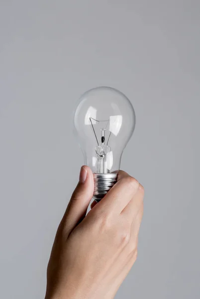 Realistic photo of Light bulb turn off in woman hand.