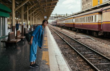 Asyalı kadın gezgin bekleyen Tren Tren İstasyonu-seyahat ve ulaşım kavramı platformunda