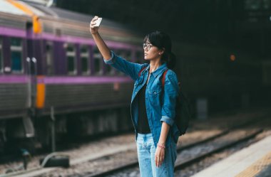 Asyalı kadın gezgin kullanılan akıllı telefon selfie fotoğraf bekle bir