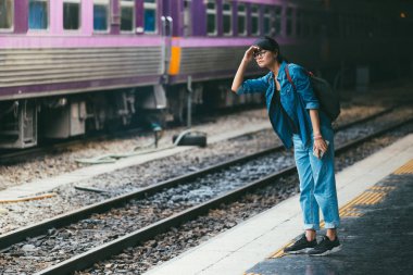 Asyalı kadın gezgin bekleyen Tren demiryolu platformu