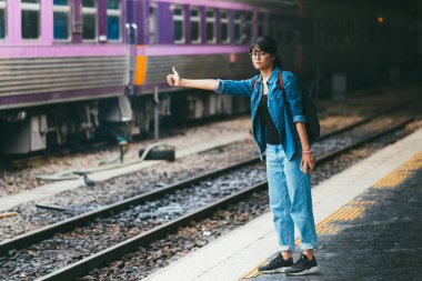 Asyalı kadın gezgin bekleyen Tren demiryolu platformu