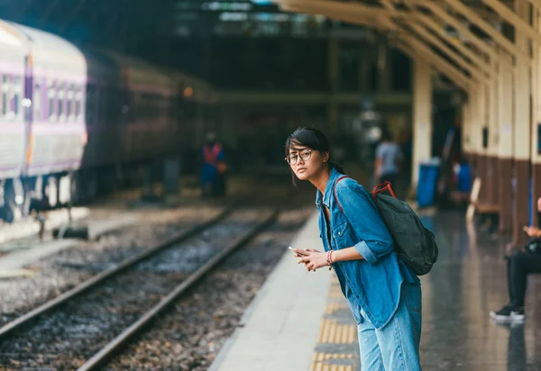 Asyalı kadın gezgin bekleyen Tren demiryolu platformu