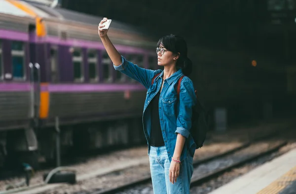 Asyalı kadın gezgin kullanılan akıllı telefon selfie fotoğraf bekle bir Stok Fotoğraf