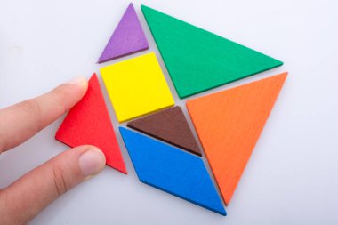 Tangram bulmacasının kayıp parçasını tutan el.