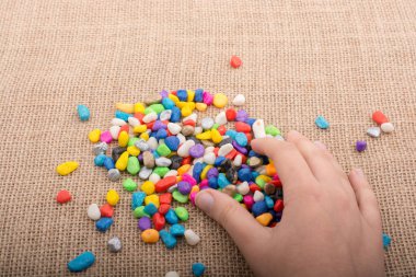 Elindeki ve yerdeki renkli çakıl taşları