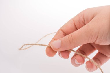 Keten iplik beyaz bir arka plan üzerinde tutan el