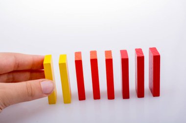 Beyaz arka planda el ele tutuşan renkli domino taşları