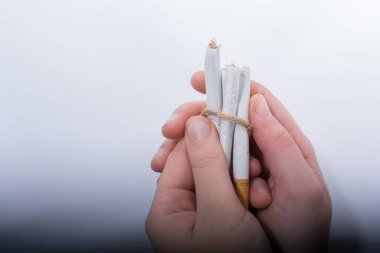 Elini paket sigara beyaz arka plan üzerinde tutuyor