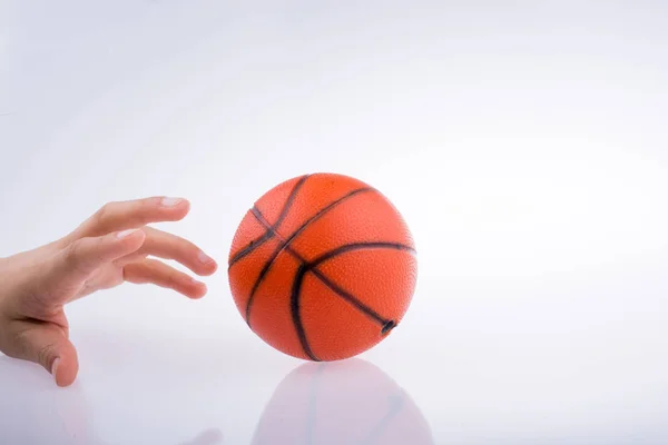 白地にオレンジのバスケット ボールのモデルを持っている手 — ストック写真