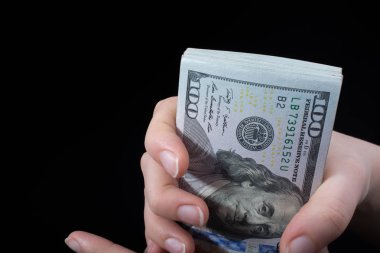 Beyaz arka planda el ele tutuşan Amerikan doları banknotları