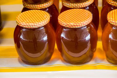 Kapaklı taze bal dolu cam kavanoz.