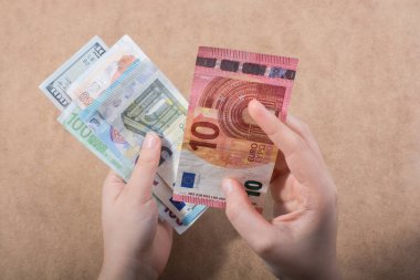 El ele tutuşan Amerikan doları banknotları ahşap arka planda izole edilmiş.