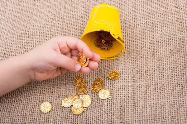 Kova ve sahte altın el üzerinde arka plan bez