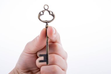 Beyaz arka planda eski moda metal bir anahtar tutan el.