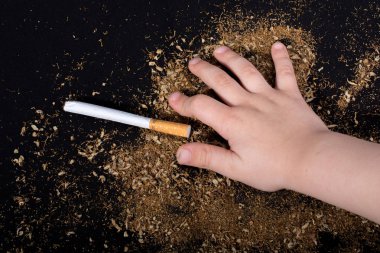 El siyah arka planda bir sigara tutuyor.