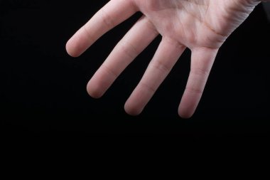 Bir çocuğun dört parmağı kısmen siyah arkaplanda görülüyor