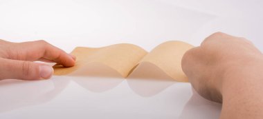 Beyaz arka planda bir sayfa kağıt tutarken