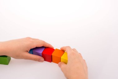 Beyaz arka planda renkli küplerle el oynamak