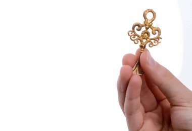 Beyaz arka planda eski moda metal bir anahtar tutan el.