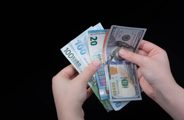 Hand holding American dollar  banknotes isolated on black background