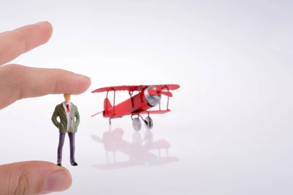 Dłoń Trzymająca Czerwony Samolot Ludzką Postać Białym Tle — Zdjęcie stockowe