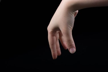 Bir çocuğun beş parmağı kısmen siyah arkaplanda görülüyor