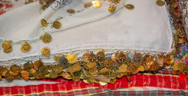 Plenty of fake gold coins are on the scarf edges