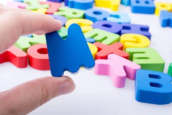 Buchstabe Der Hand Neben Bunten Buchstabenblöcken Die Zufällig Verstreut Sind — Stockfoto