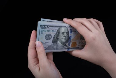 Beyaz arka planda el ele tutuşan Amerikan doları banknotları