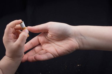 El siyah arka planda sigara kırıyor.