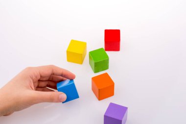 Beyaz arka planda renkli küplerle el oynamak