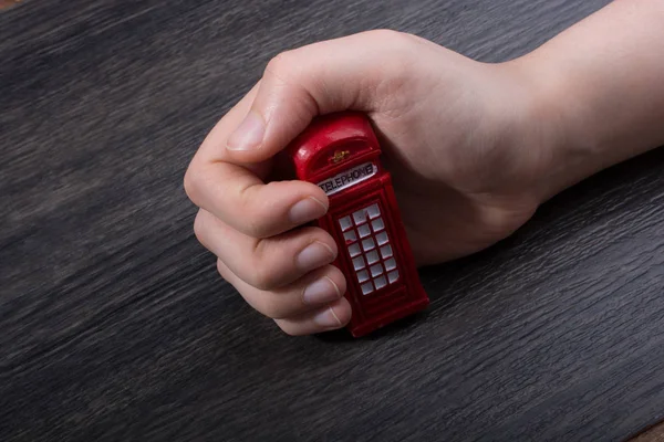 Hand Hält Eine Telefonzelle Auf Braunem Hintergrund — Stockfoto