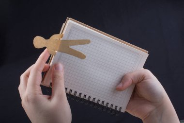 Elinde not defteriyle kağıttan kesilmiş bir adam.