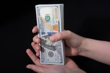 Beyaz arka planda el ele tutuşan Amerikan doları banknotları