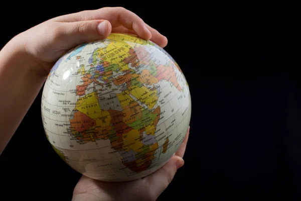 Hand holding a globe  with map on it