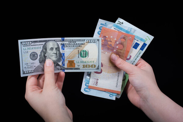 Hand holding American dollar  banknotes isolated on black background
