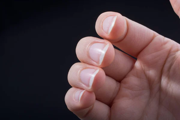 Four fingers of a child hand partly seen in black background