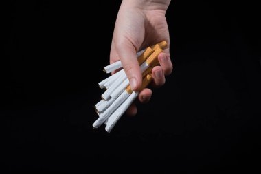 El, siyah arka planda bir paket sigara dağıtıyor.