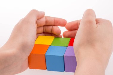 Beyaz arka planda renkli küplerle el oynamak