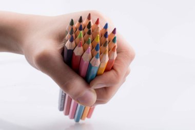 Beyaz arkaplanda el ele tutuşan renkli kalemler