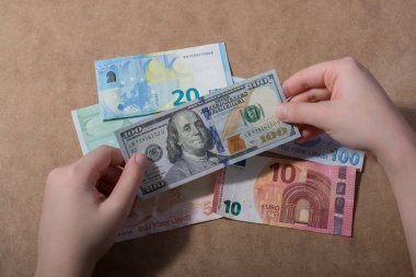 El ele tutuşan Amerikan doları banknotları ahşap arka planda izole edilmiş.