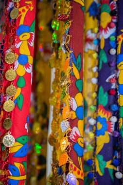 Eşarp kenarlarında bir sürü sahte altın para var.