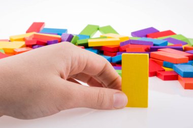 Beyaz arkaplanda renkli domino taşıyla el oyunu