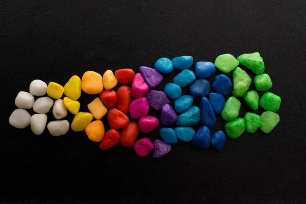 Siyah arkaplanda küçük renkli çakıl yığınları