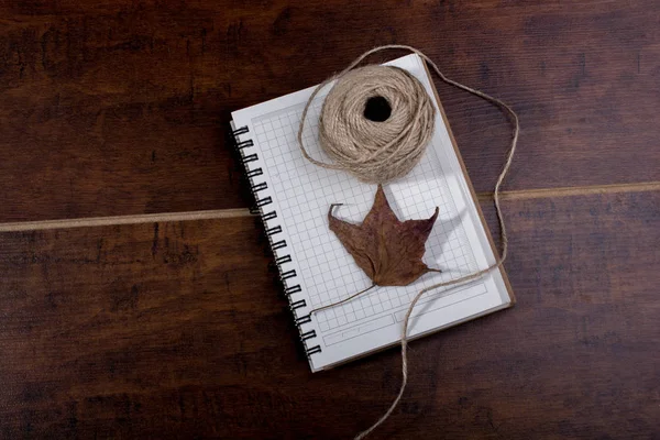 Defter, yaprak ve biriktirme dize kahverengi zemin üzerine