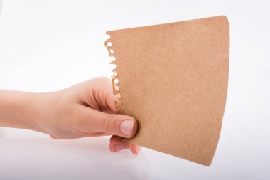 Beyaz arka planda bir sayfa kağıt tutarken